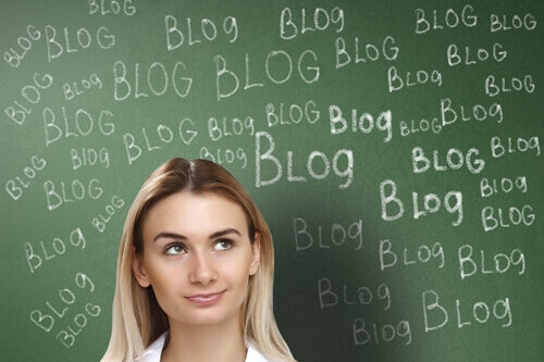 6-marketing-and-design-blogs-to-follow_ woman standing in front of chalkboard with blog written