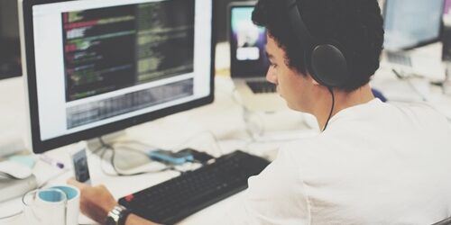 Are you looking to hire a front end web developer or hoping to find a job as one? Front end web developer writing code at his computer.