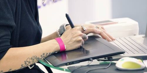 Are you looking to hire a graphic designer or hoping to find a job as one? Here’s what you need to know. graphic designer working on tablet