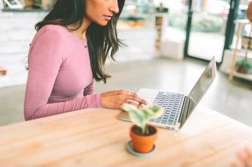 As a contract employee, you may have the autonomy to work remotely. young woman works in public space with laptop