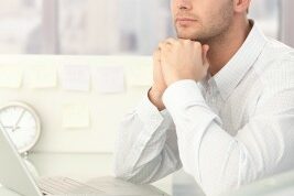 Businessman-daydreaming man looking off into the distance at his desk