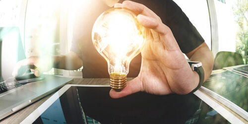 How can numbers make your resume stand out from the crowd? Man holding up a lightbulb that is lit on top of a tablet