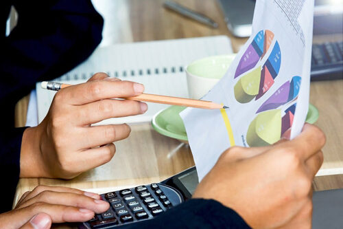 Sales and marketing need to work together to maximize lead generation. People looking at graphs on paper at a desk