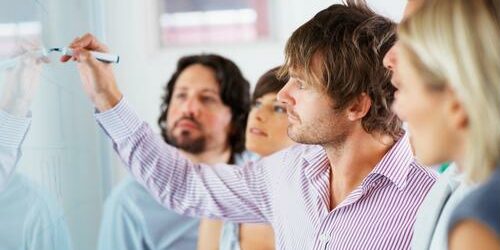Web project manager working with team members to develop new web solution. Web project manager leading team of creative and technical professionals.