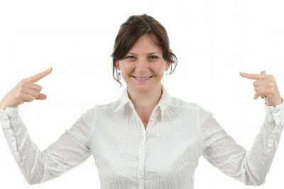Woman-pointing-at-herself woman smiling pointing at herself