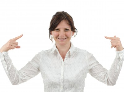 Woman-pointing-at-herself woman smiling pointing at herself