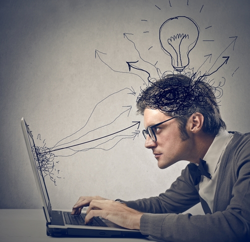 Aside from proper grammar and stellar proofreading skills, there are many other qualities to look for in your next copywriter. man working on a laptop with cartoon arrows and lightbulb all over his head