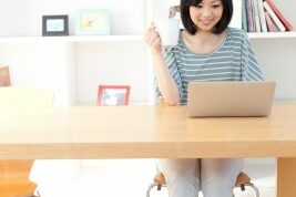 blogging woman working at her desk in a bright office
