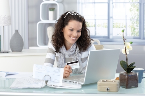 Boost engagement with content that has been geo-localized woman smiling at her laptop holding a card