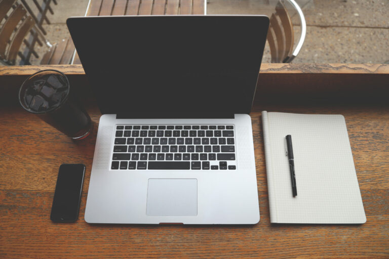 Remote Workers coffee iphone and laptop on wooden desk