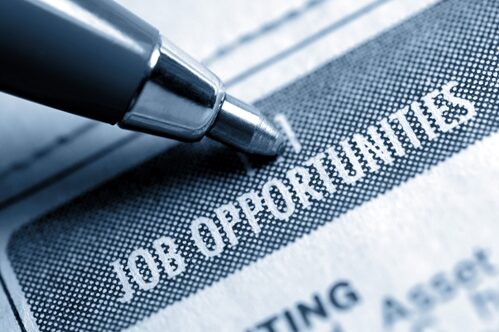 Conduct a discreet job search while you are employed pen pointing to job opportunities in a paper