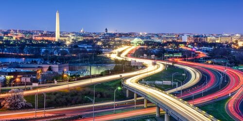 dc_jobs City scape of Washington DC at night with cars driving by