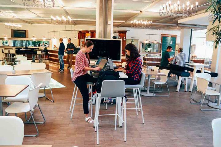 employee-experience-for-all-generations-1 two woman working in a cafe at a communal table