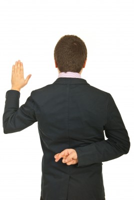 fingerscrossed man with his fingers crossed behind his back as he makes a promise