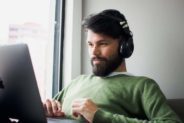 man on laptop listening to music Man On Laptop Listening to Music for Productivity