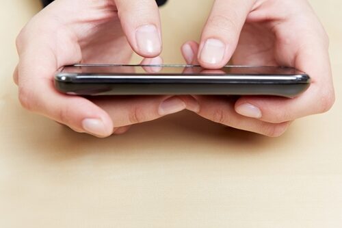 Mobile development trends for 2013 Person holding their phone, close up is on their hands