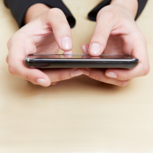 Mobile development trends for 2013 Person holding their phone, close up is on their hands