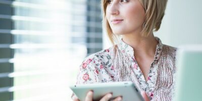 recruiter woman looking out the window as she works on a tablet