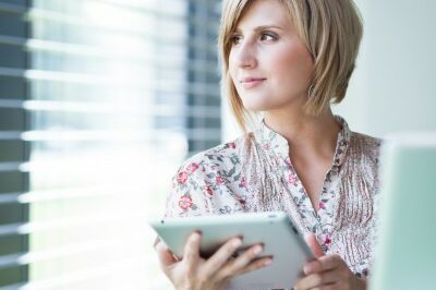recruiter woman looking out the window as she works on a tablet