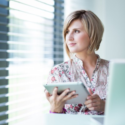 recruiter woman looking out the window as she works on a tablet