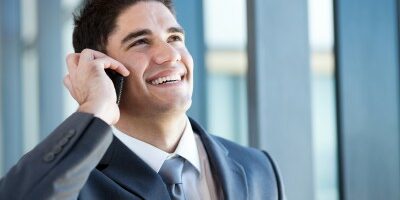 reference man smiling while he talks on the phone