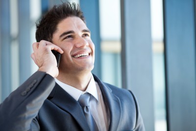 reference man smiling while he talks on the phone