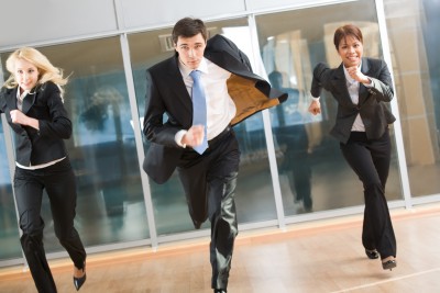 running 3 business professionals running down a hallway