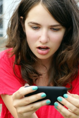 socialmediashocked woman angry as she looks at her phone