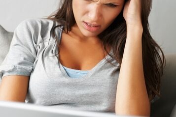 There are certain strategies to try when experiencing a roadblock in your hunt for your next career. woman stressing while working at a laptop