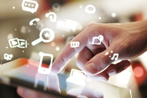 There are new tools that have emerged in the world of social media that are going to change the way you work for the better. Master a few of them to help with your everyday tasks, advancing your career and giving you the edge you need at top marketing firms. man touching a tablet with cartoon icons coming off of the screen