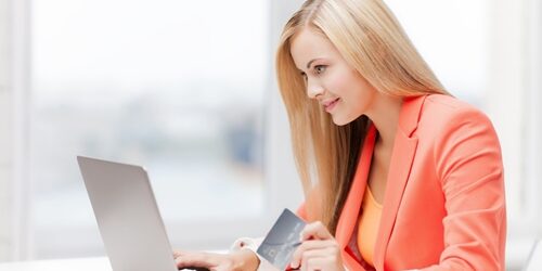 Tips for reaching your target audience woman on her laptop in an office with a credit card in her hand