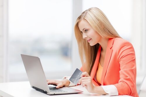 Tips for reaching your target audience woman on her laptop in an office with a credit card in her hand