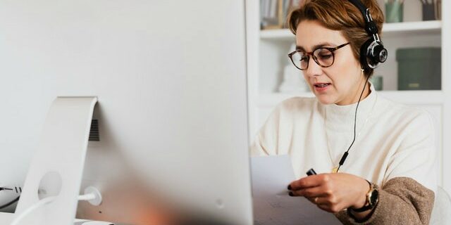 tips for virtual interviewing woman looking at resume while virtual interviewing