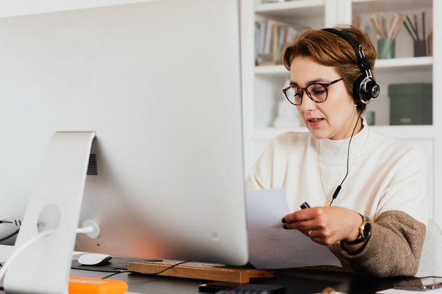 tips for virtual interviewing woman looking at resume while virtual interviewing