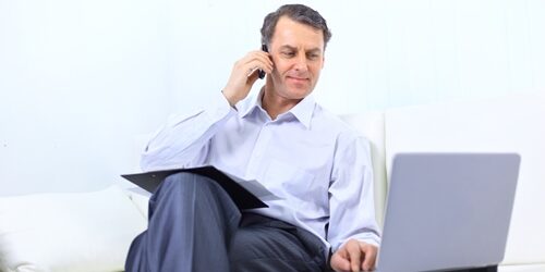 Top issues human resource professionals will experience in 2013 man on his phone working on his laptop on a couch