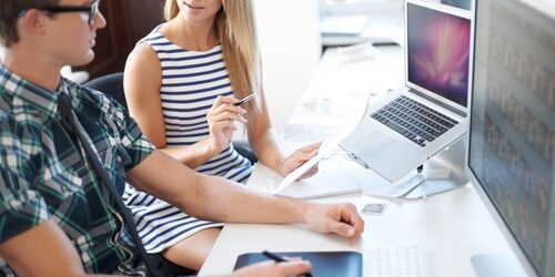 What a UX-job candidate will have to bring to the table Coworkers sitting at a desk in front of their computers discussing