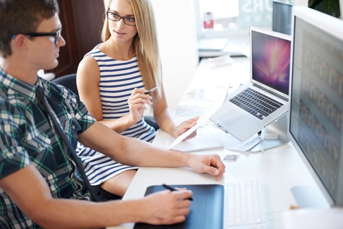What a UX-job candidate will have to bring to the table Coworkers sitting at a desk in front of their computers discussing