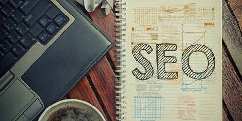 A Marketer’s Refresher to SEO Best Practices wooden desk and computer with notebook SEO