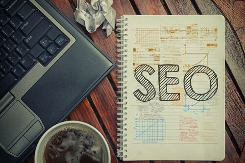 A Marketer’s Refresher to SEO Best Practices wooden desk and computer with notebook SEO