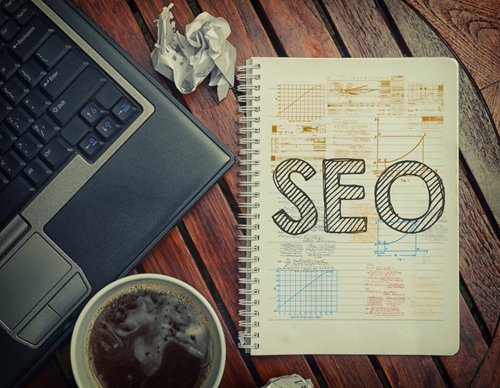 A Marketer’s Refresher to SEO Best Practices wooden desk and computer with notebook SEO