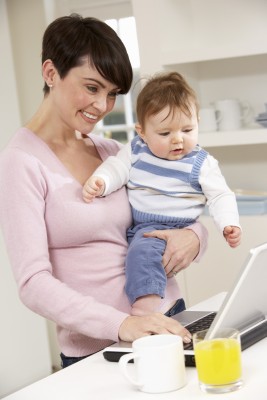 workfromhome woman working from home as she holds her baby