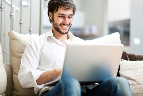 Writing a strong cover letter has always been a concern for job-seekers. With the digitization of networking and employment applications, not to mention the invasion of email, the stakes are now higher than ever – and most people are confused as to where the cover letter fits in to the recipe. man smiling as he works at his laptop on his couch