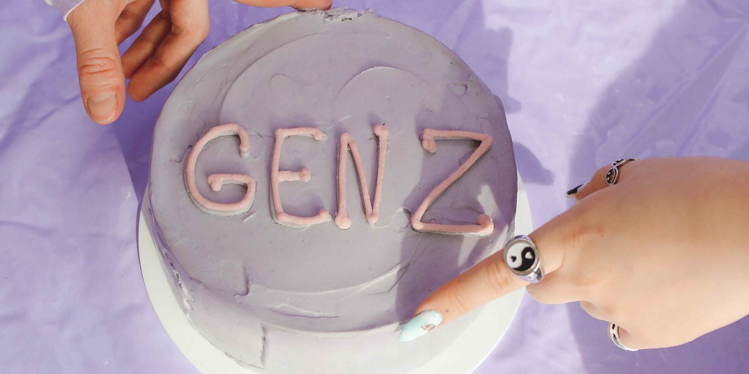 Gen z in the workplace hands on light purple cake that says "gen z" - gen z in the workplace