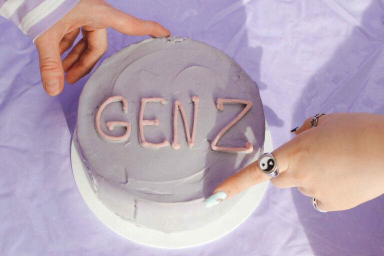 Gen z in the workplace hands on light purple cake that says "gen z" - gen z in the workplace