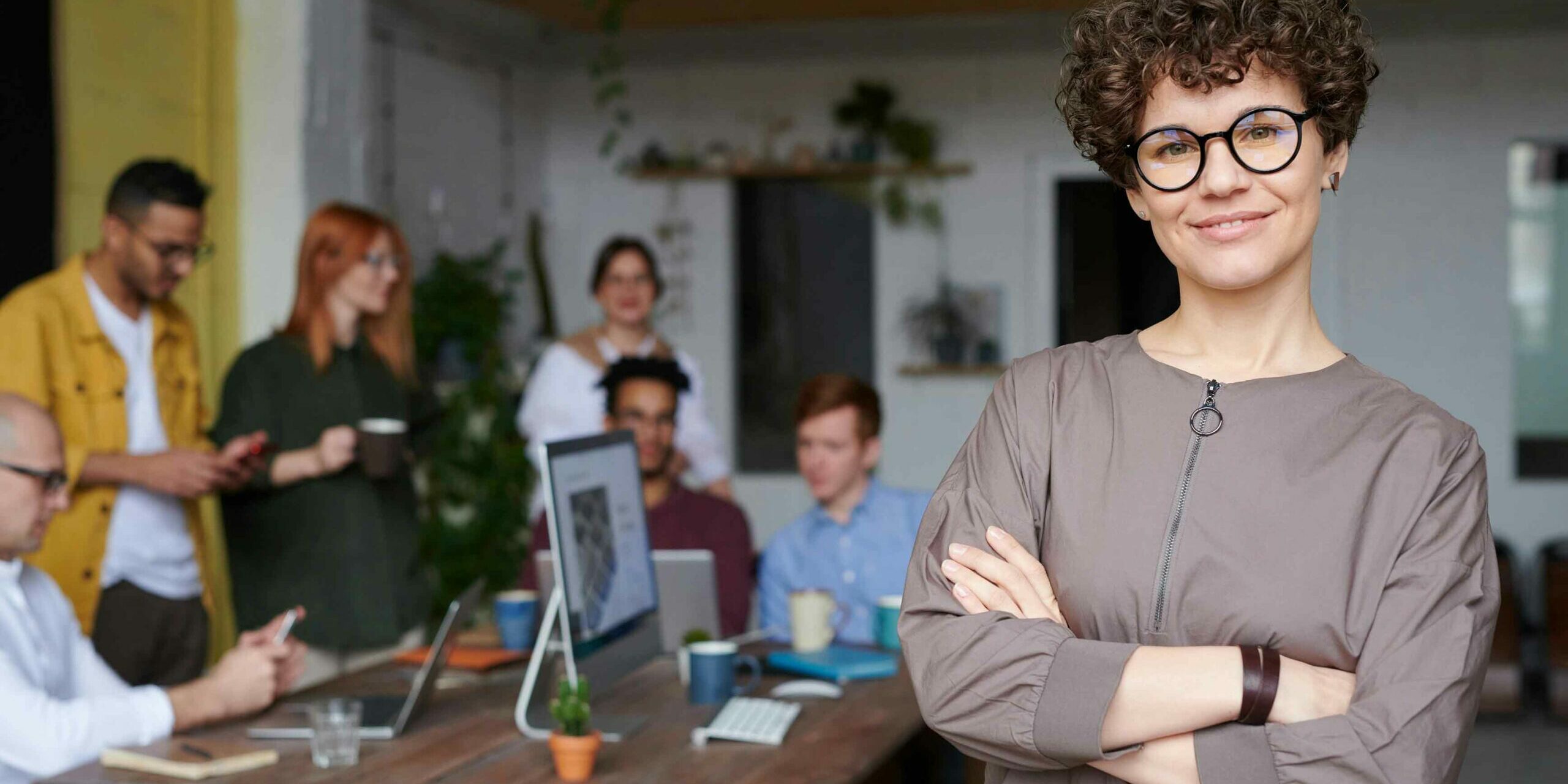 How Do Successful CMOs Leverage Staffing Agencies for Growth Successful woman CMO with her arms crossed in front of her team