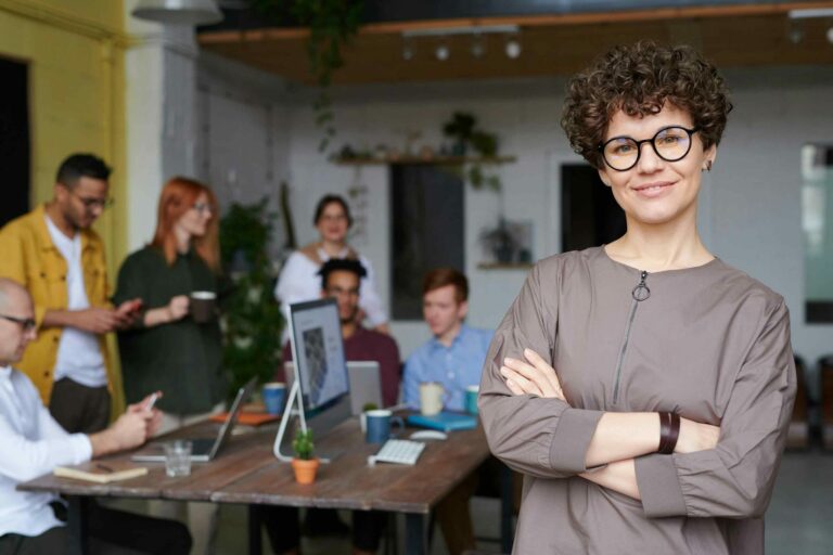 How Do Successful CMOs Leverage Staffing Agencies for Growth Successful woman CMO with her arms crossed in front of her team