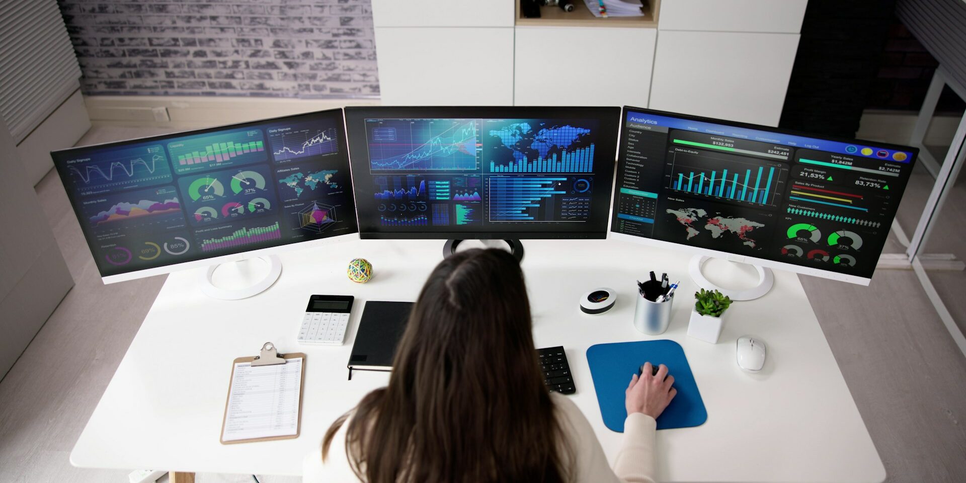 how to hire a data scientist woman data scientist sitting at a computer with three screens of data