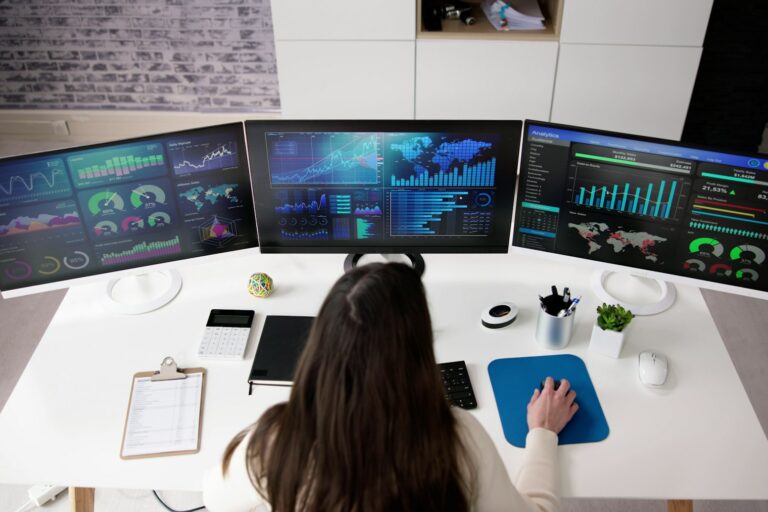 how to hire a data scientist woman data scientist sitting at a computer with three screens of data