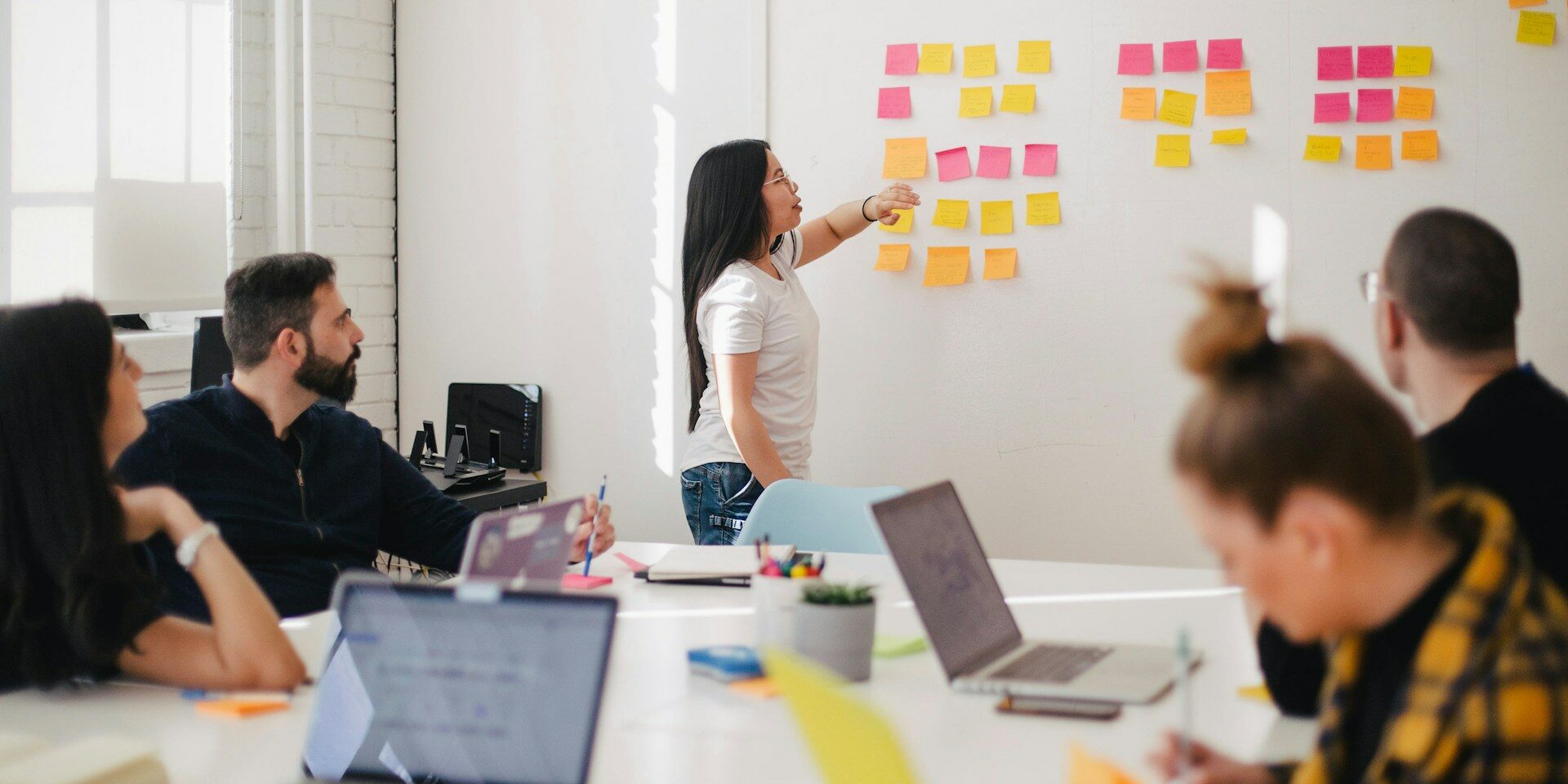 how to hire a web designer woman at wall with post-it for a web designer meeting