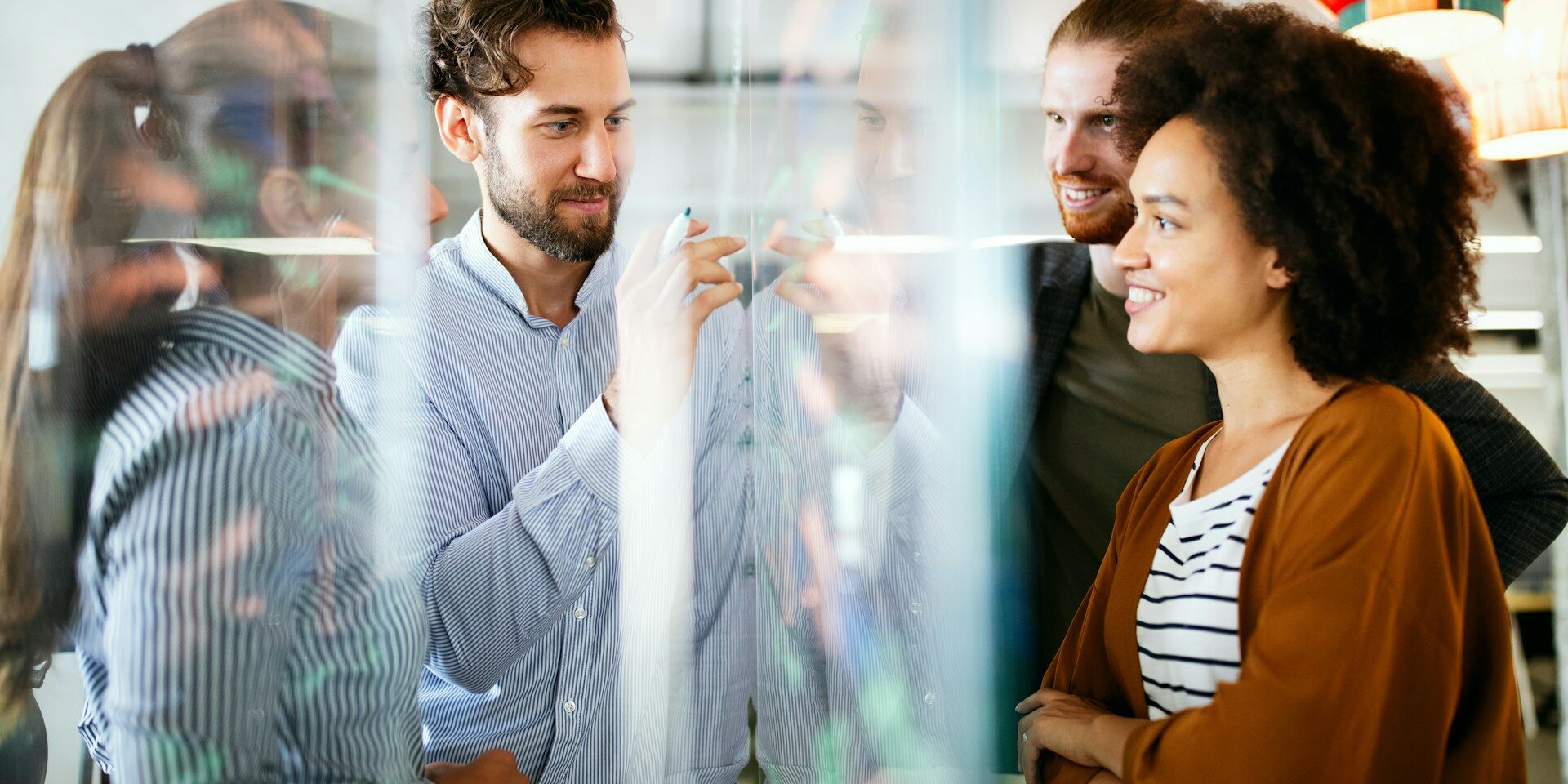 reasons embedded teams outperform traditional outsourcing group of professionals around a clear white board